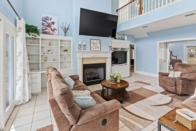 a living room with furniture a flat screen tv and a fireplace