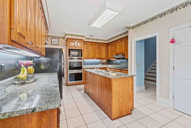 a kitchen with stainless steel appliances granite countertop a refrigerator and a sink