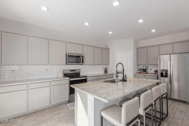 a kitchen with stainless steel appliances granite countertop a sink stove and microwave