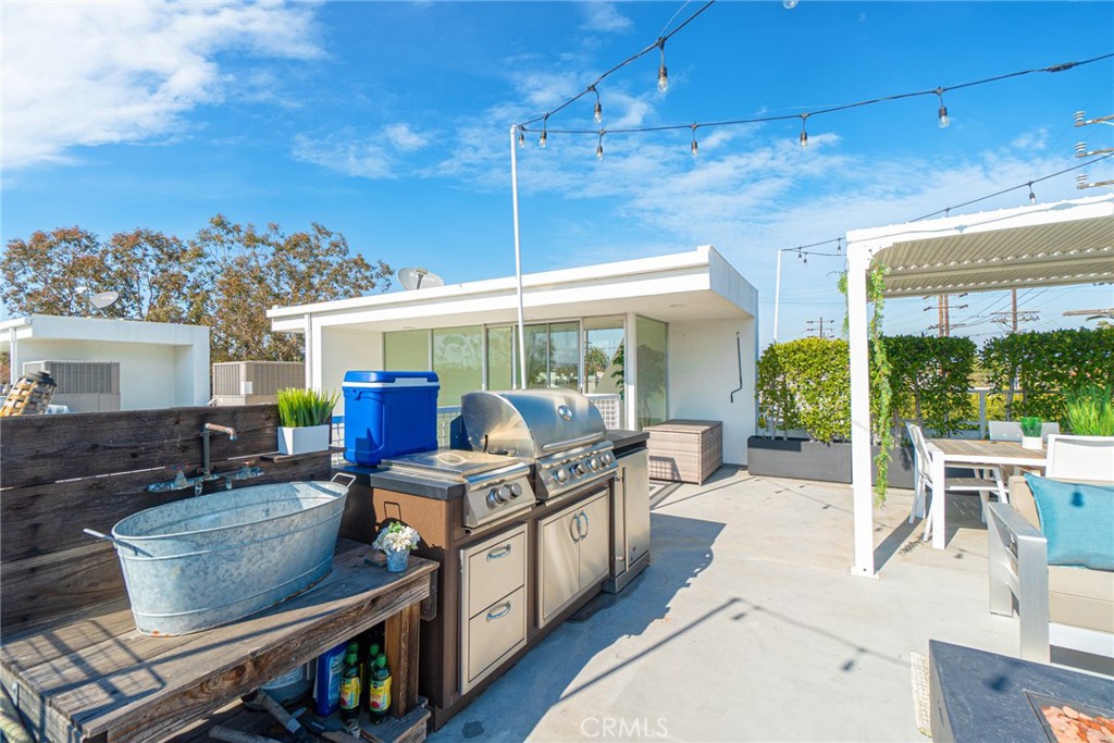 938 Palms Boulevard, Unit 2 Venice, CA 90291 - Photo 44 of 46 a living room with furniture a flat screen tv and a floor to ceiling window