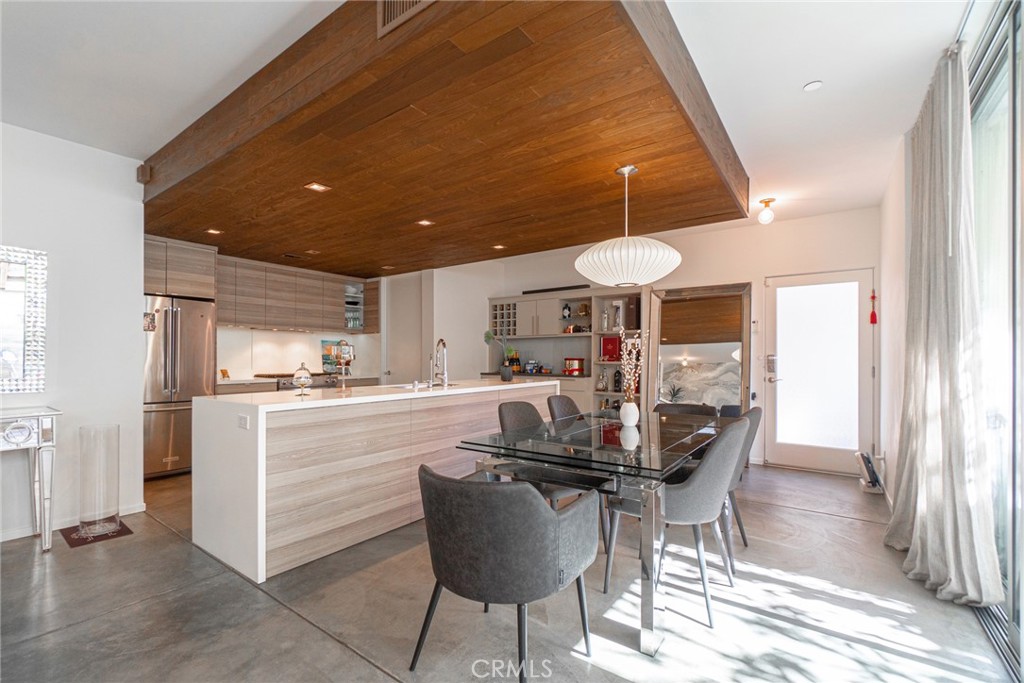938 Palms Boulevard, Unit 2 Venice, CA 90291 - Photo 9 of 46 a kitchen with stainless steel appliances kitchen island granite countertop a table chairs and a refrigerator