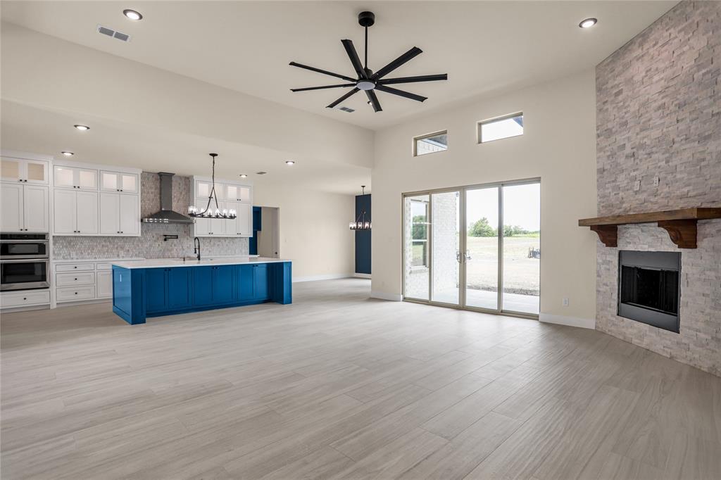 7637 County Road 1052 Celeste, TX 75423 - Photo 12 of 40 Unfurnished living room featuring a fireplace, a chandelier, a ceiling fan, light wood finished floors, and recessed lighting