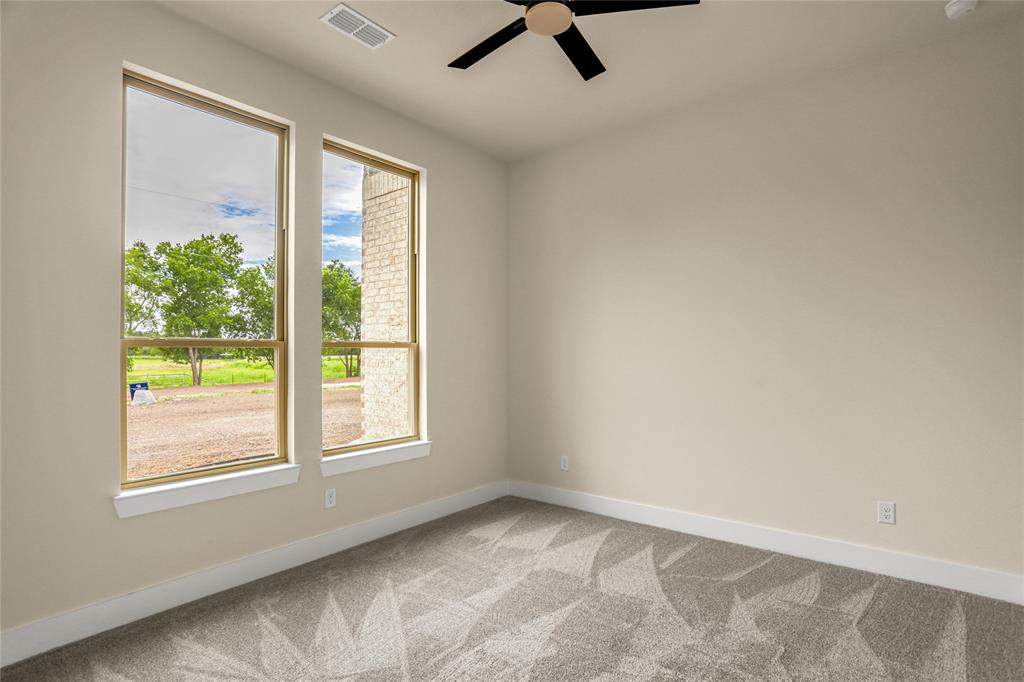 7637 County Road 1052 Celeste, TX 75423 - Photo 25 of 40 Spare room featuring light colored carpet, plenty of natural light, and ceiling fan