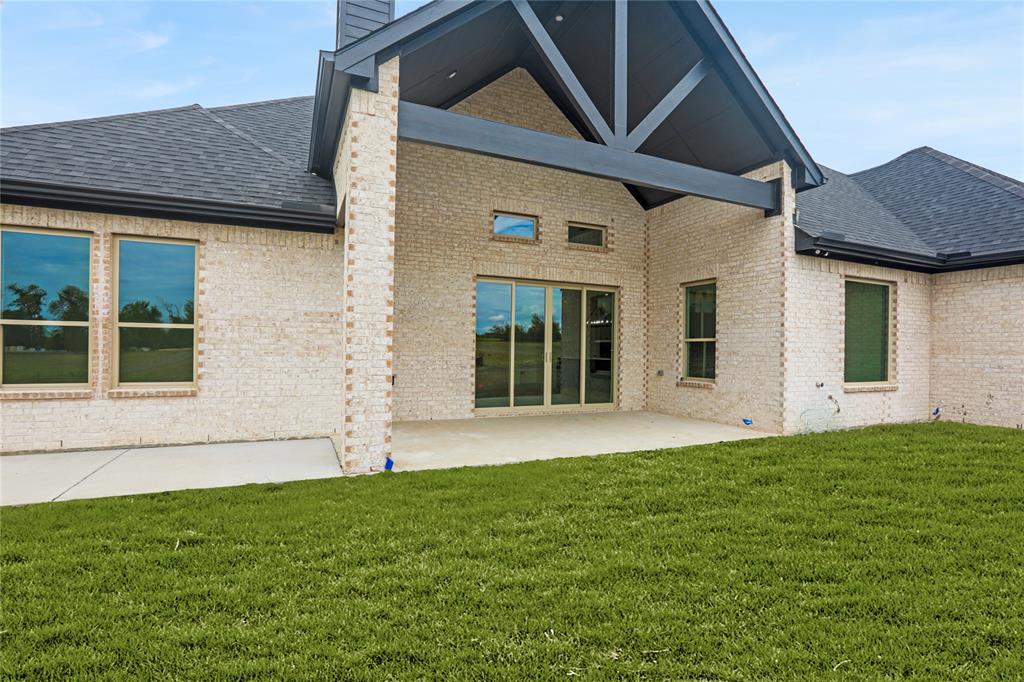 7637 County Road 1052 Celeste, TX 75423 - Photo 37 of 40 Back of house featuring roof with shingles, a patio, brick siding, and a chimney