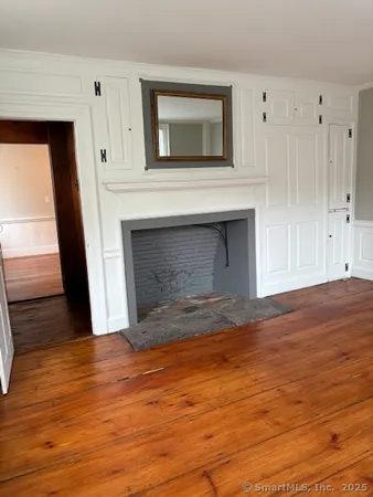 a view of empty room with wooden floor and fireplace