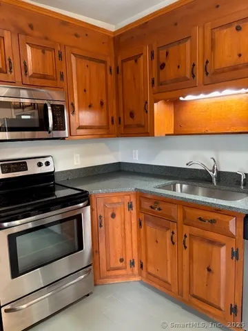 a kitchen with stainless steel appliances granite countertop a stove microwave and cabinets