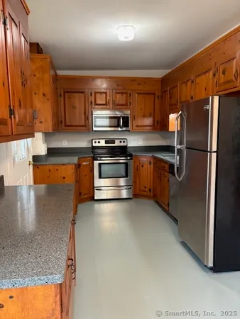 a kitchen with stainless steel appliances granite countertop a stove a sink and a refrigerator