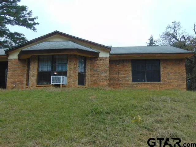 a view of a chair and table in backyard of the house