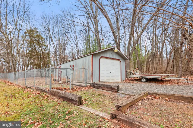 a backyard of a house with wooden fence and large trees