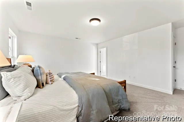 a bed sitting in a bedroom next to a window