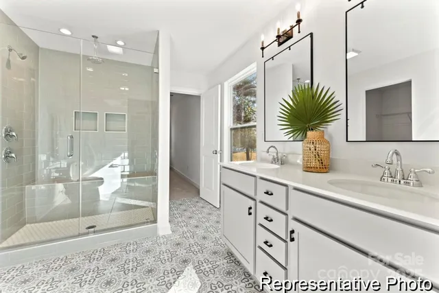 a bathroom with a double vanity sink mirror and shower