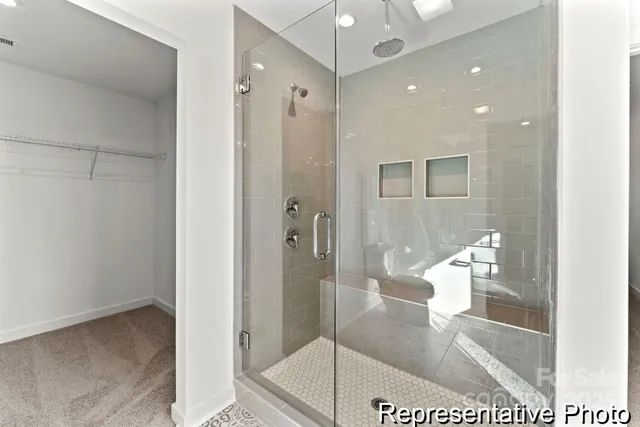 a bathroom with a glass shower door and a bathroom