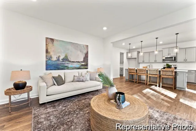 a living room with furniture and a dining table with kitchen view