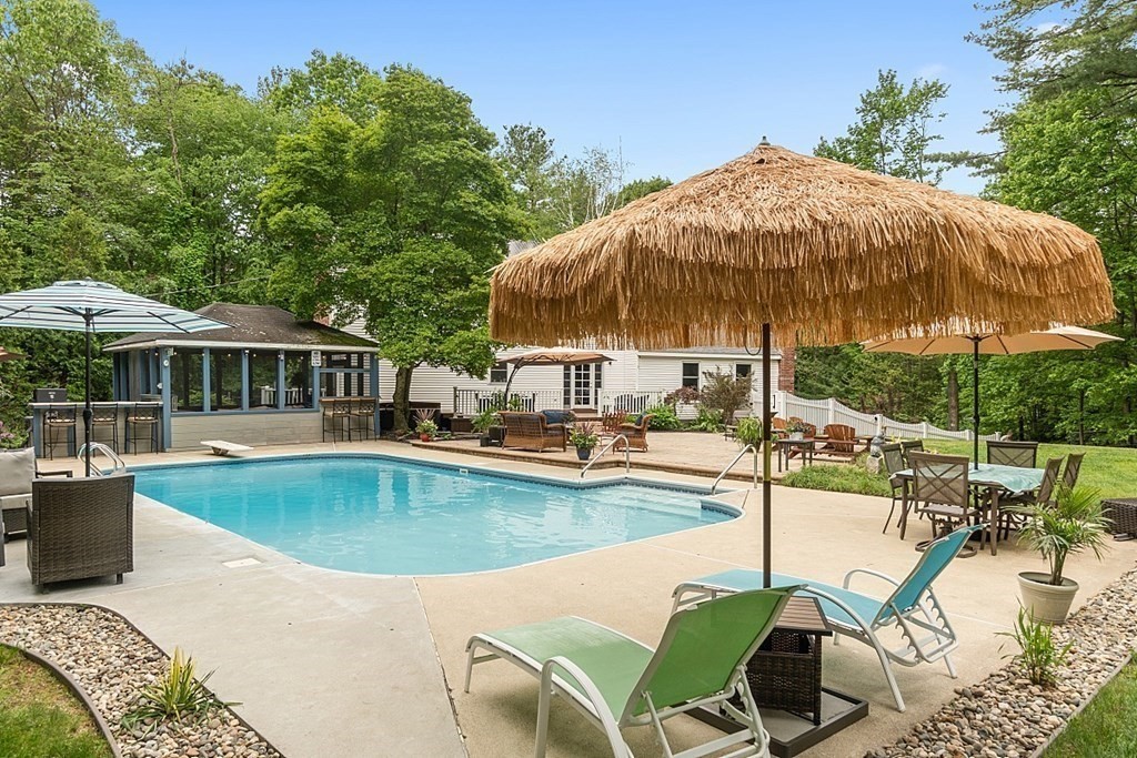 237 Hollis Road Lunenburg, MA 01462 - Photo 29 of 42 a view of a swimming pool with a table and chairs under an umbrella