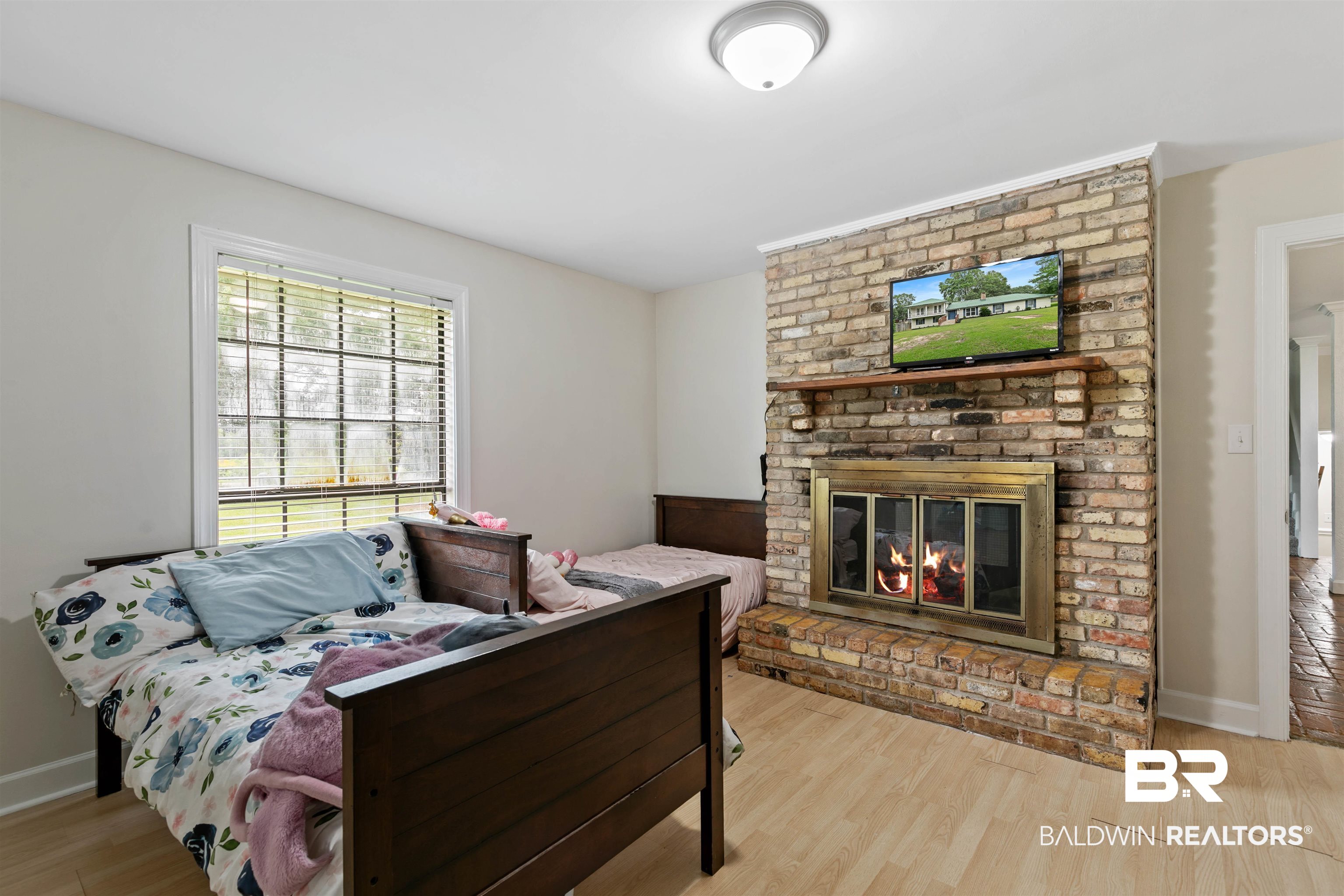 10420 Johnson Road South Mobile, AL 36695 - Photo 28 of 75 Brick fireplace with a brass firebox, flanked by a light wood-finish flooring