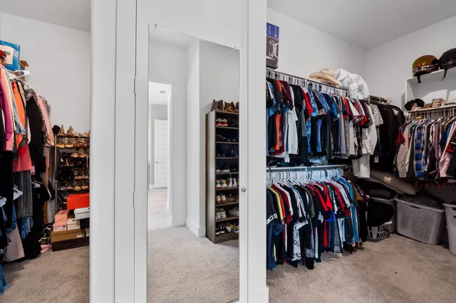 a view of walk in closet with clothes and shoes