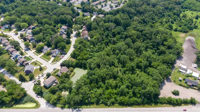 an aerial view of residential houses with outdoor space and trees