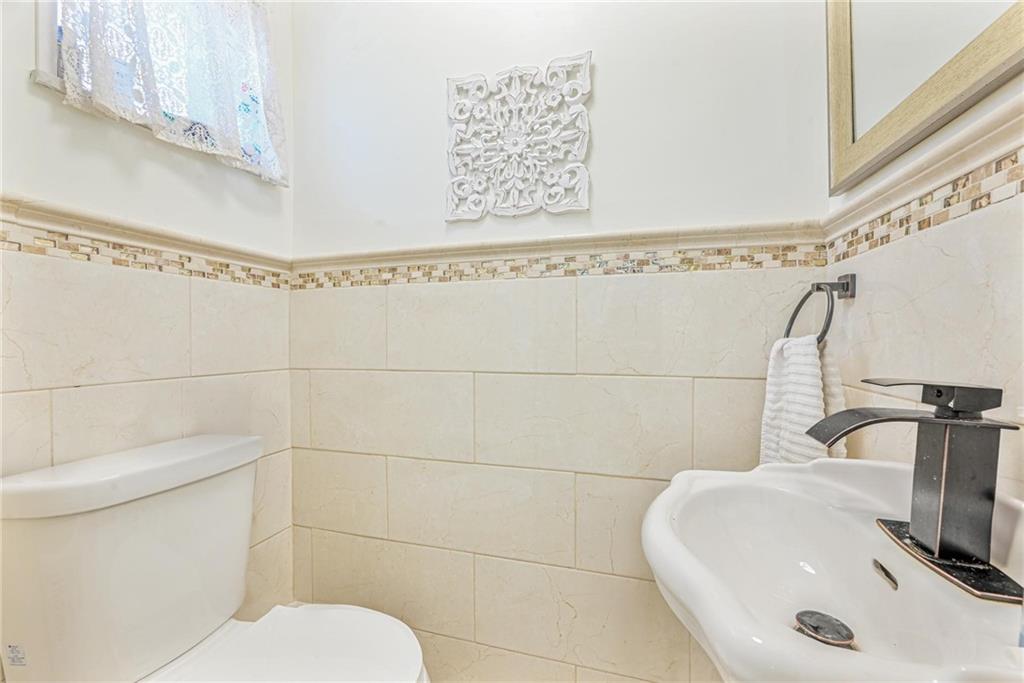 1237 82nd Street Brooklyn, NY 11228 - Photo 13 of 24 a bathroom with a sink a toilet and a mirror
