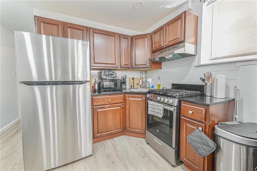 1237 82nd Street Brooklyn, NY 11228 - Photo 16 of 24 a kitchen with stainless steel appliances granite countertop a refrigerator sink and cabinets