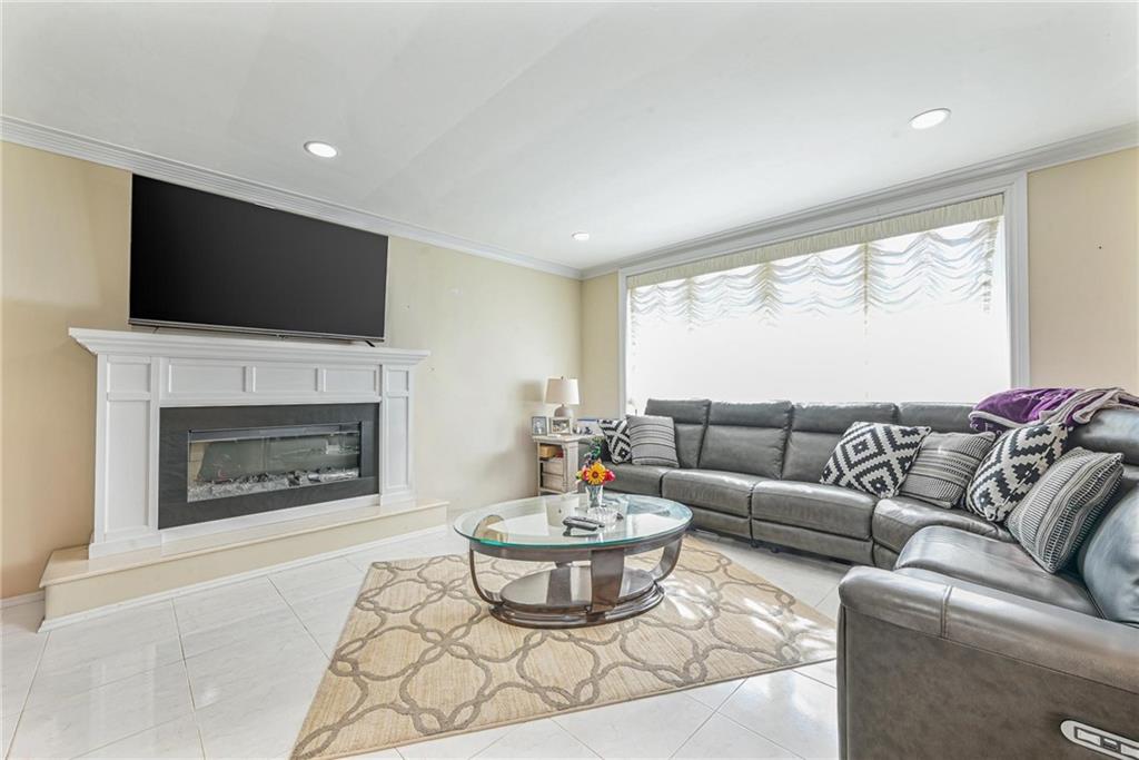1237 82nd Street Brooklyn, NY 11228 - Photo 6 of 24 a living room with furniture a fireplace and a flat screen tv