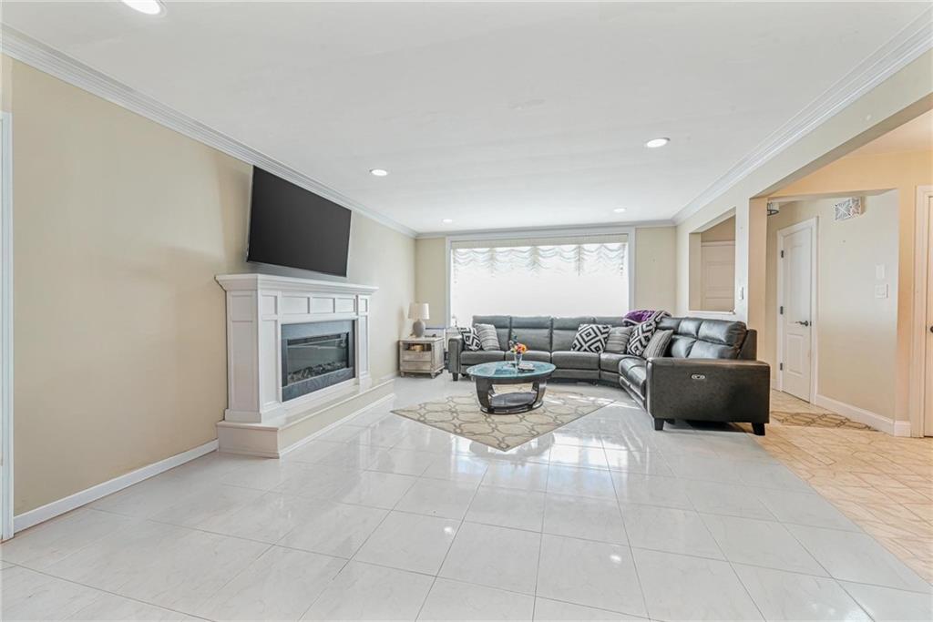 1237 82nd Street Brooklyn, NY 11228 - Photo 7 of 24 a living room with furniture a fireplace and a flat screen tv