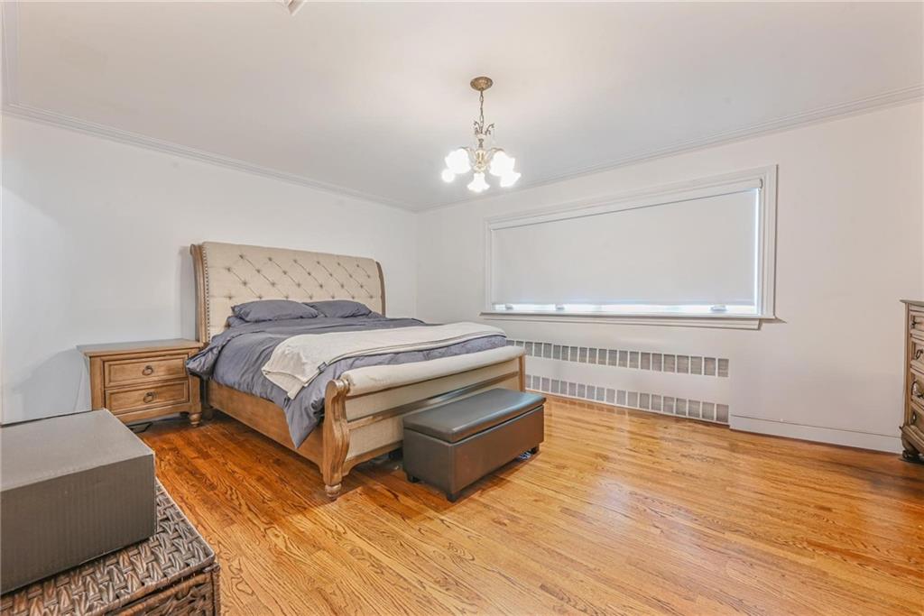 1237 82nd Street Brooklyn, NY 11228 - Photo 10 of 24 a bedroom with a bed and wooden floor