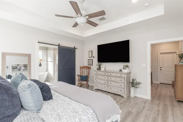 a bedroom with a large bed and a chandelier