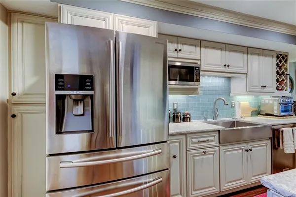 a kitchen with stainless steel appliances granite countertop a refrigerator and a stove