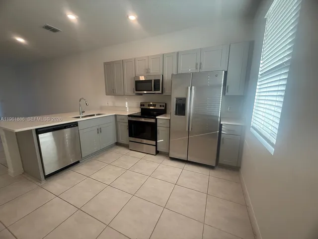 a kitchen with stainless steel appliances granite countertop a stove a sink a microwave and a refrigerator