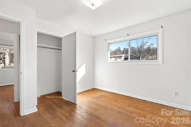 a view of a backyard with table and chairs potted plants and large tree