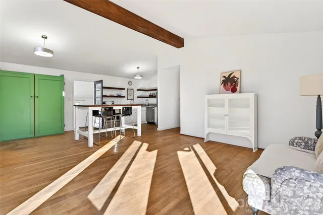 a front view of a house with large trees