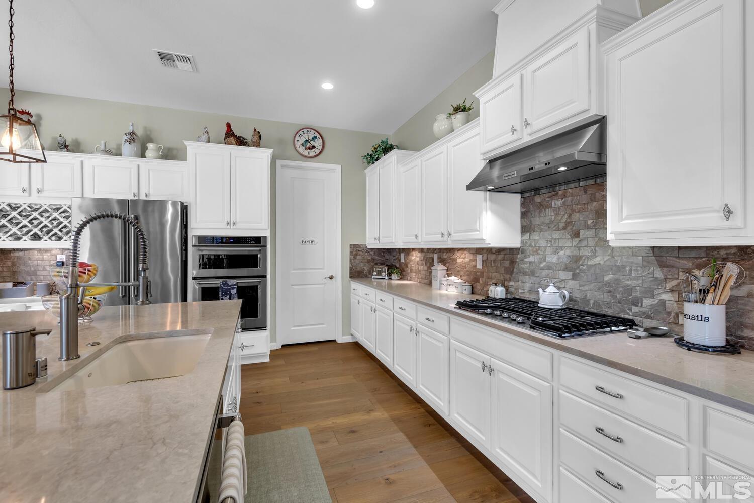 9775 Thesolious Lane Reno, NV 89521 - Photo 11 of 40 a kitchen with stainless steel appliances kitchen island granite countertop a refrigerator and cabinets