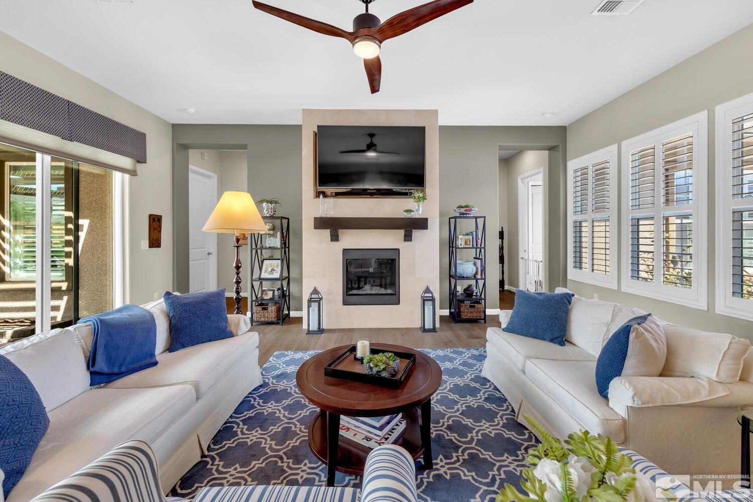 9775 Thesolious Lane Reno, NV 89521 - Photo 18 of 40 a living room with furniture a flat screen tv and a fireplace