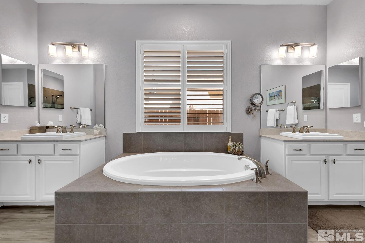9775 Thesolious Lane Reno, NV 89521 - Photo 31 of 40 a bathroom with a tub a sink double vanity and a window