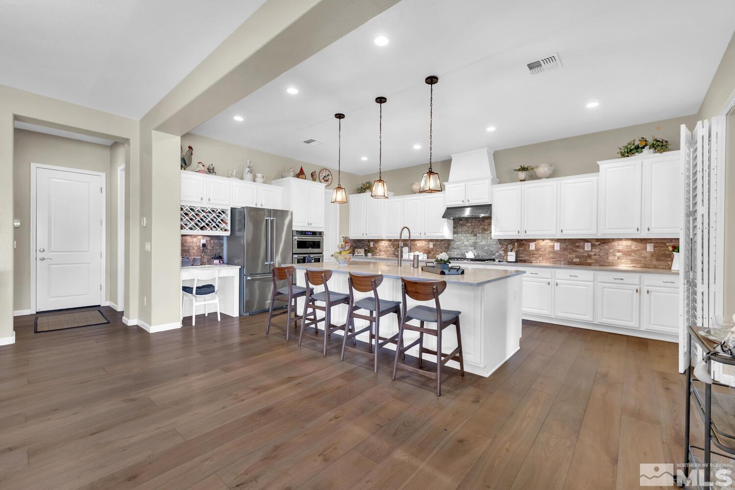 9775 Thesolious Lane Reno, NV 89521 - Photo 7 of 40 a kitchen with stainless steel appliances kitchen island granite countertop a stove a refrigerator and a microwave