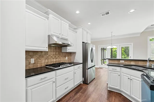 a kitchen with granite countertop white cabinets and white appliances
