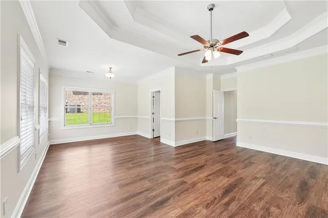 a view of an empty room with window and wooden floor