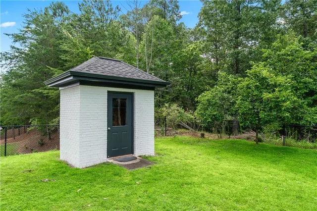 a backyard of a house with plants and large tree