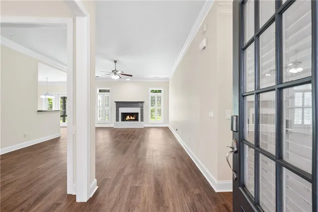 wooden floor in an empty room with a fireplace and a window