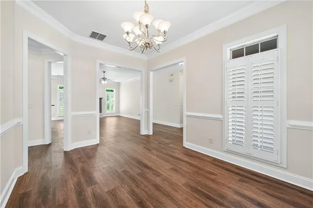 a view of a hallway with wooden floor and a chandelier