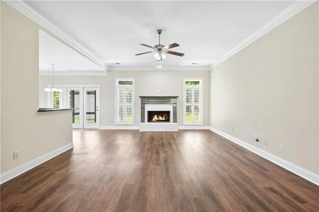 an empty room with fireplace wooden floor and windows