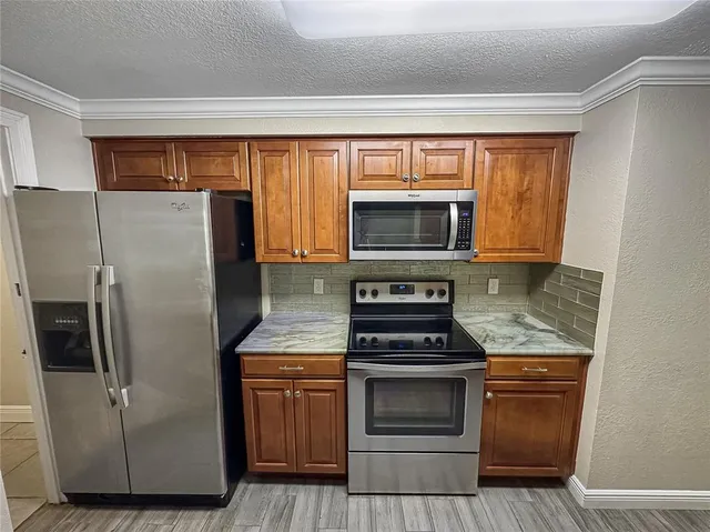 a kitchen with a refrigerator stove and microwave