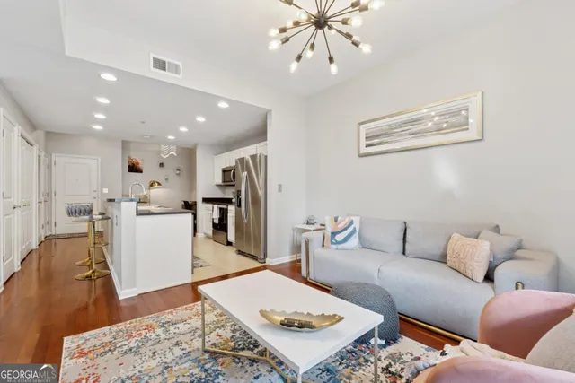 a living room with furniture and a view of kitchen
