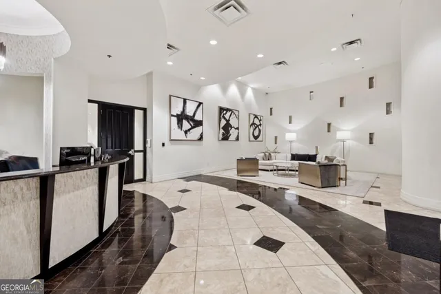 a large white kitchen with stainless steel appliances kitchen island granite countertop a refrigerator and a sink