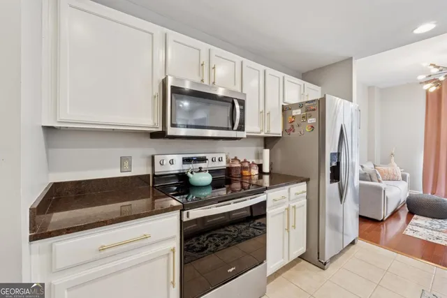 a kitchen with granite countertop a refrigerator stove and microwave