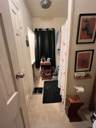a hallway with painting on the wall and a large mirror