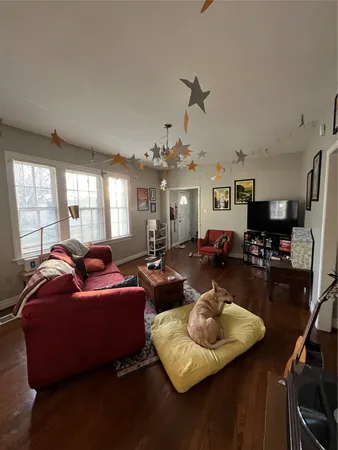 a living room with furniture kitchen view and a window