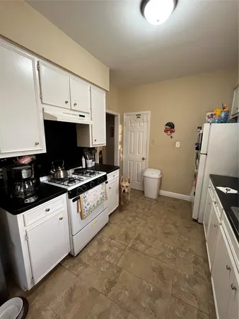 a kitchen with granite countertop a sink a stove and cabinets