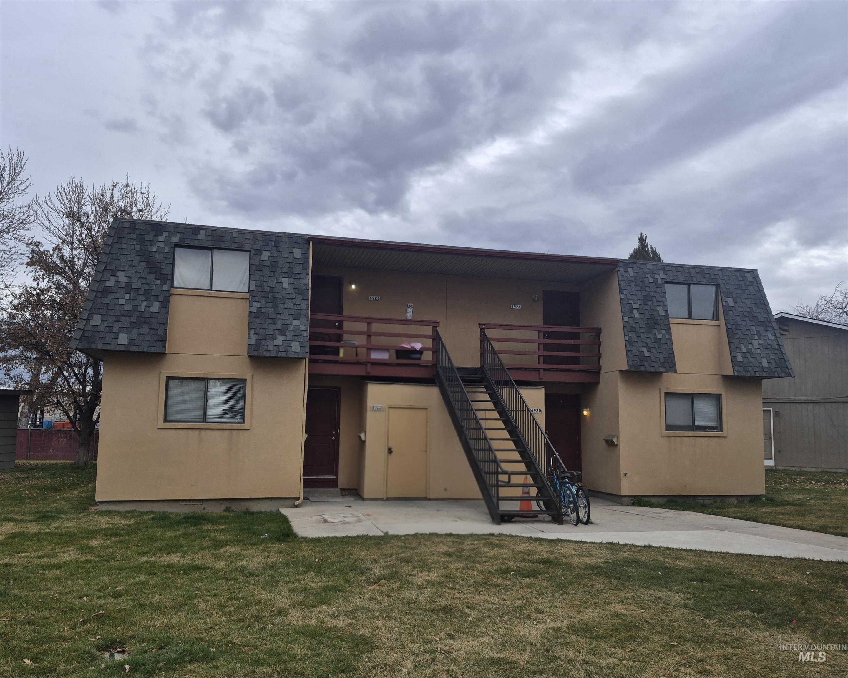 6920 West Grunder Street Boise, ID 83709 - Photo 1 of 1 Front view featuring stucco siding, mansard roof, a lawn, and roof with shingles