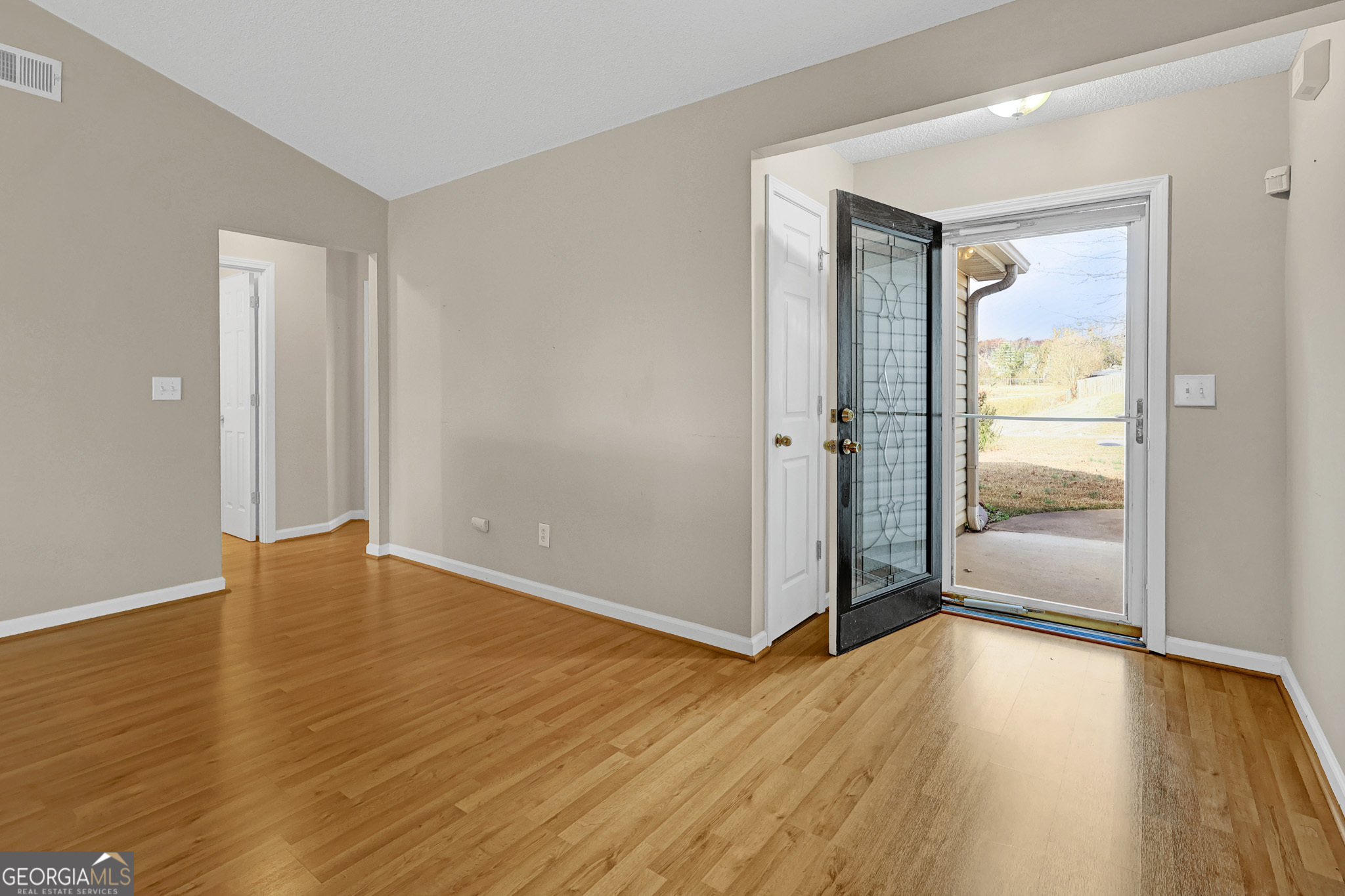 313 Harris Avenue Locust Grove, GA 30248 - Photo 11 of 34 an empty room with wooden floor and entrance